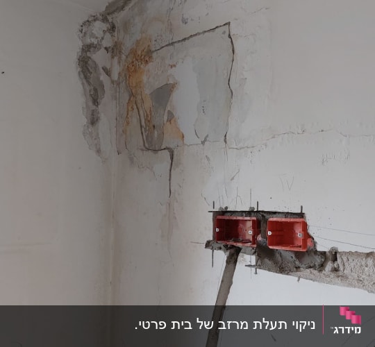 קיר עם סדקים ותיקוני טיח ליד התקרה